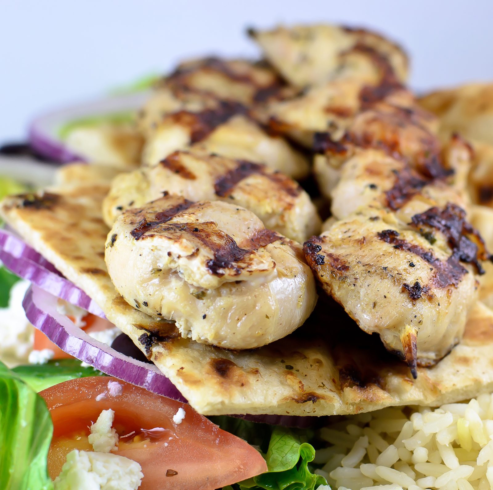 Grilled chicken on pita with rice, salad and red onion